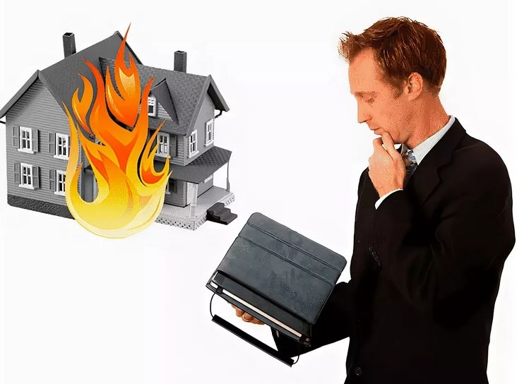 Мужчина с планшетом на фоне горящего дома